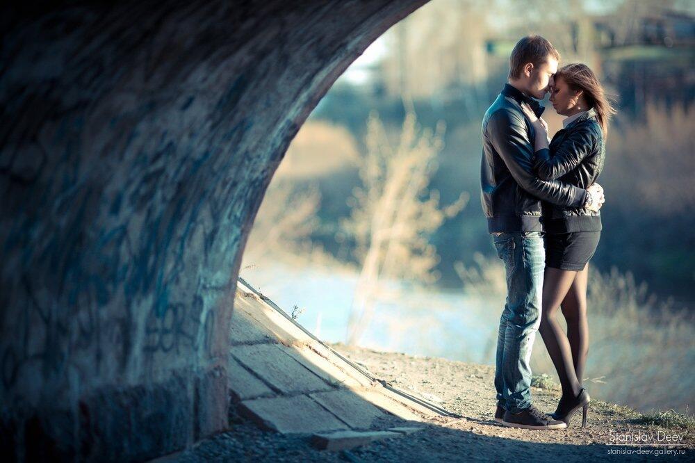 Парень целуется на улице. Влюбленные на мосту. Влюбленная пара. Влюбленные парочки. Обнимает девушку.