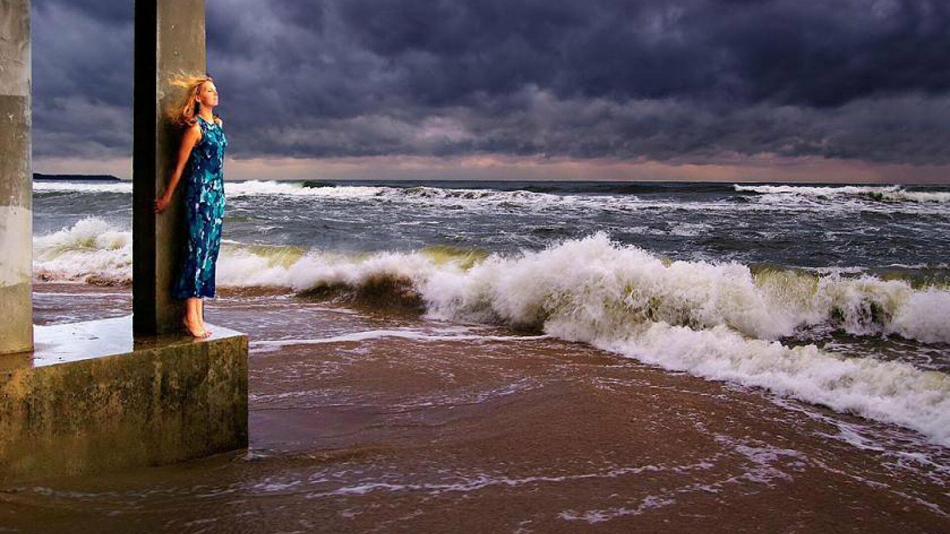 В городе ни души. Девушка море шторм. Море шторм человек. Женщина у моря в шторм. Женщина на море.