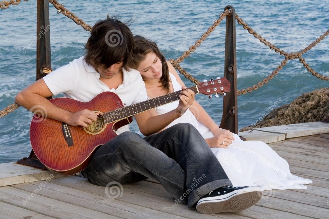 Парень играет девушке на гитаре фото