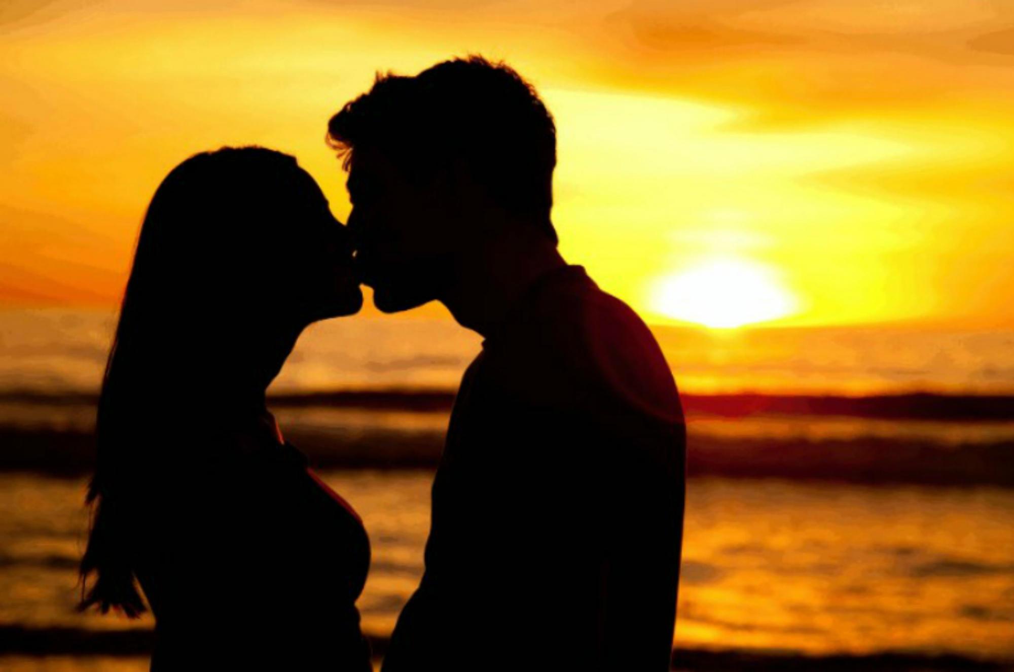 Двое. Поцелуй на закате. Любовь на закате. Парень целует девушку на закате. Поцелуй влюбленных.
