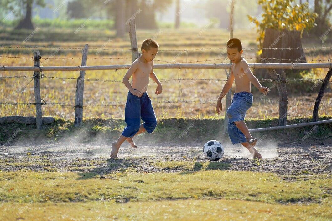 Мальчик играет в футбол. Дети играют в футбол в деревне. Детский дворовый футбол. Мальчишки гоняют мяч. Летом играем в футбол