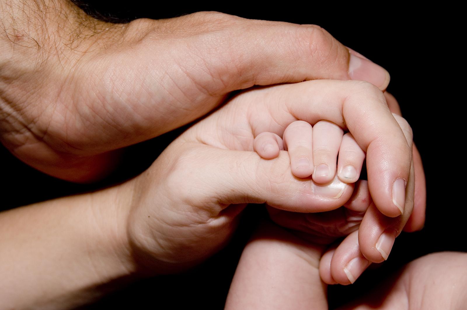 Младенец на руках у мамы и папы