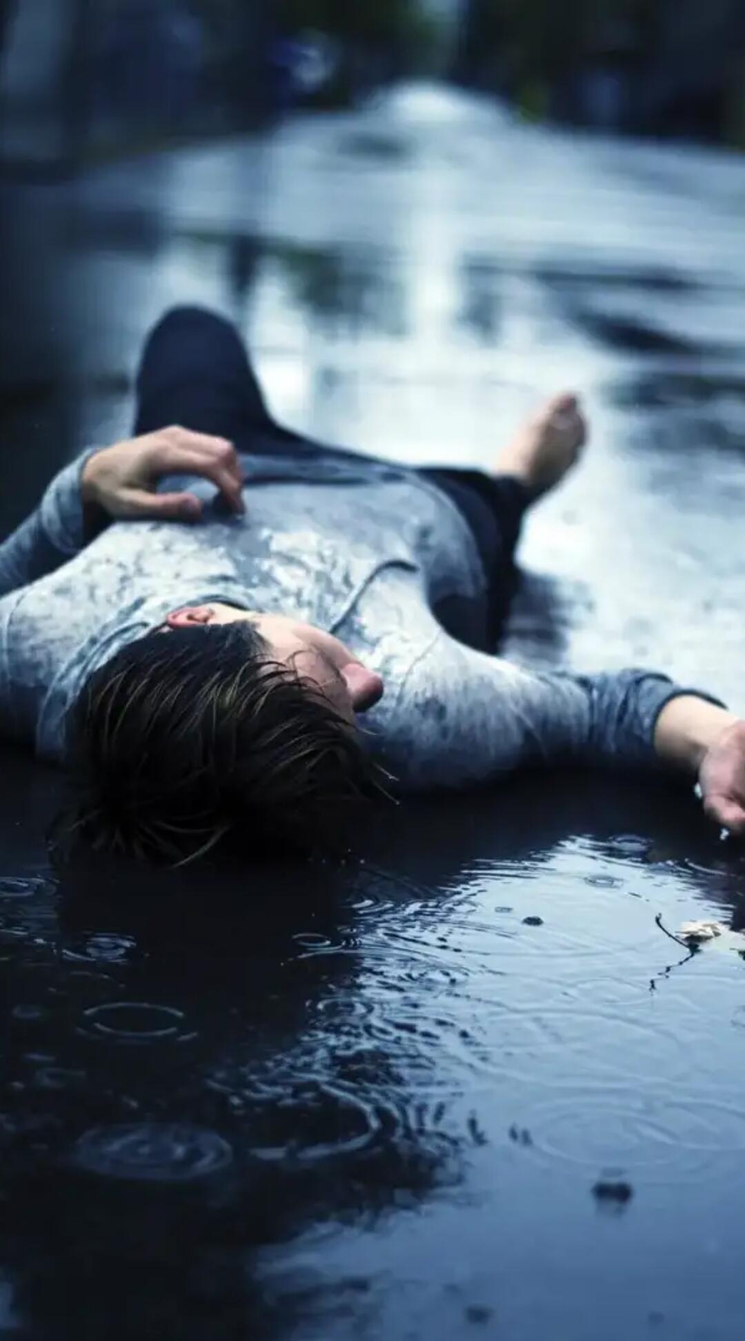 Человек умирает от боли. Парень под дождем. Грустный парень. Лежит под дождем. Печальный парень.