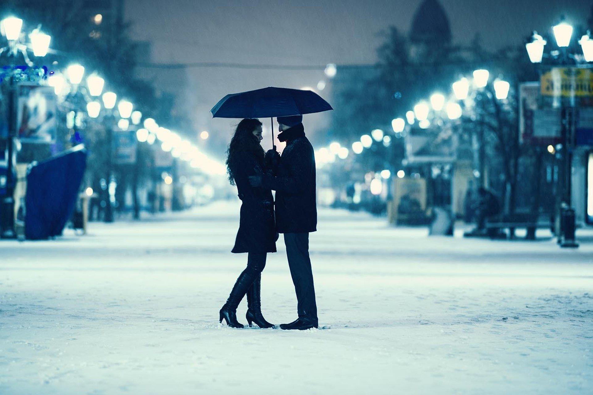 Гулять до поздна. Зимняя романтика. Пара гуляет зимой. Влюбленные в заснеженном городе. Вечерняя прогулка.